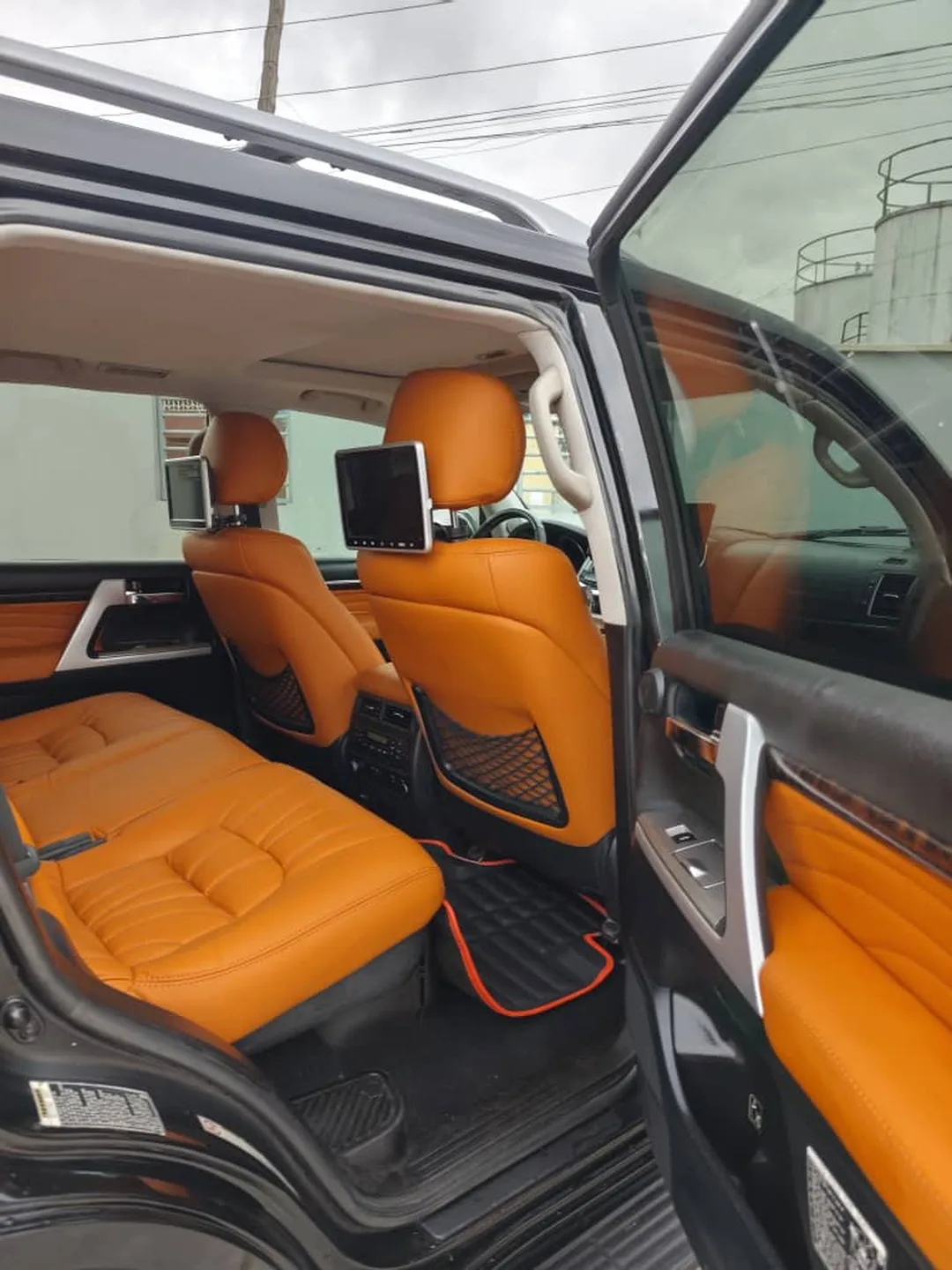 Toyota Land Cruiser V8 interior with tan leather front seats and wood-trim dashboard
